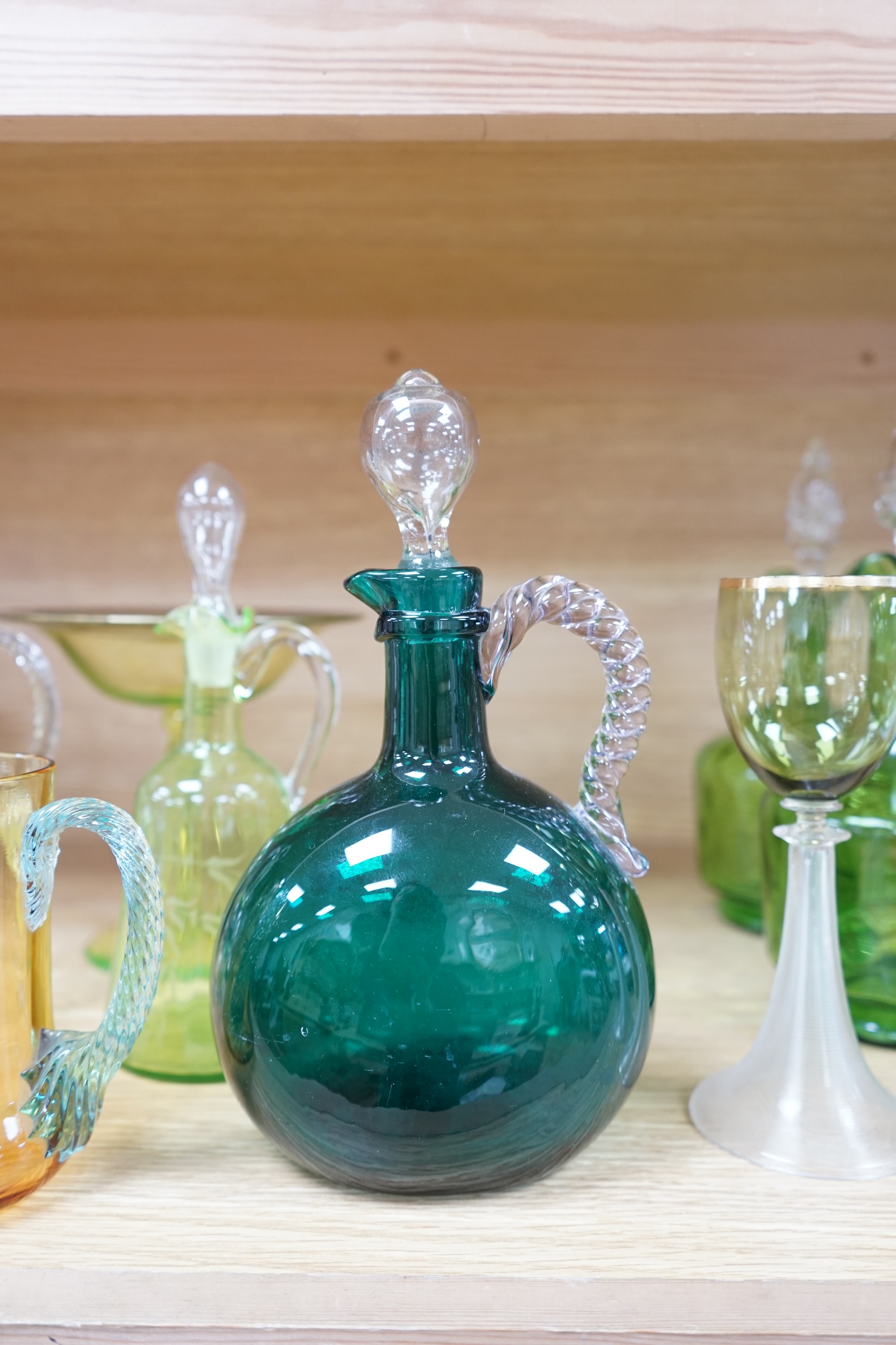 Ten glass items; a pair of green hock glasses, six liqueur decanters, a pedestal table centre and a mug. Condition - good.